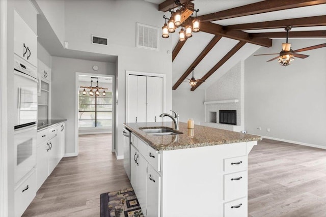 kitchen with visible vents, dishwasher, a sink, ceiling fan with notable chandelier, and open floor plan