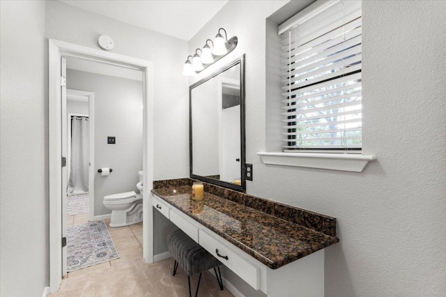 bathroom featuring vanity, a shower with shower curtain, tile patterned floors, and toilet