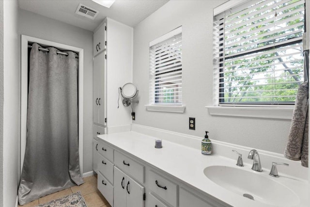 full bathroom with visible vents, plenty of natural light, tile patterned floors, and vanity