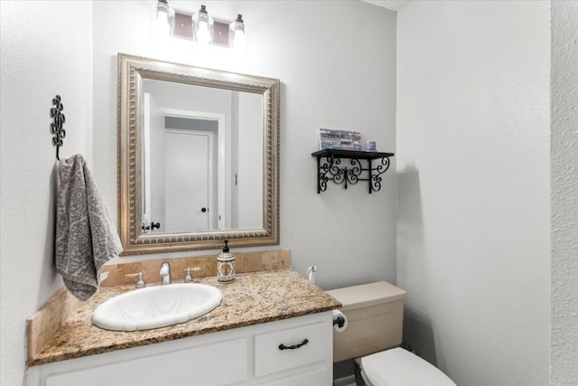 half bathroom featuring vanity and toilet