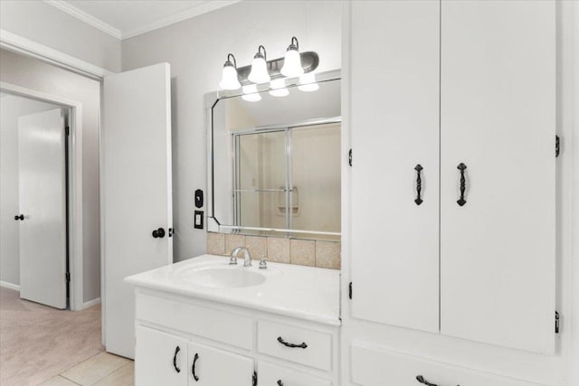 bathroom with crown molding, vanity, baseboards, and a shower stall