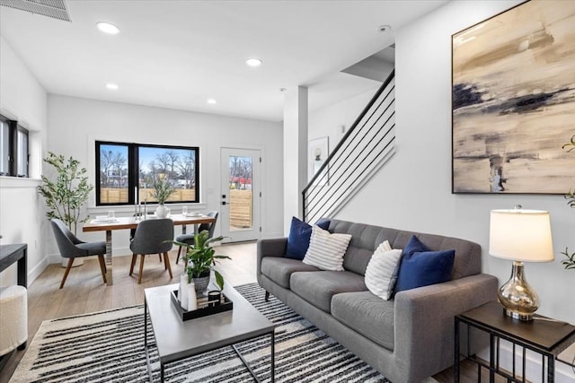 living area with stairs, recessed lighting, wood finished floors, and visible vents