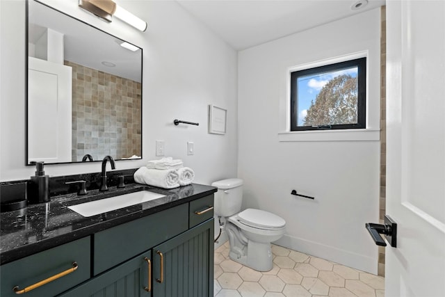 bathroom with toilet, baseboards, tile patterned flooring, and vanity