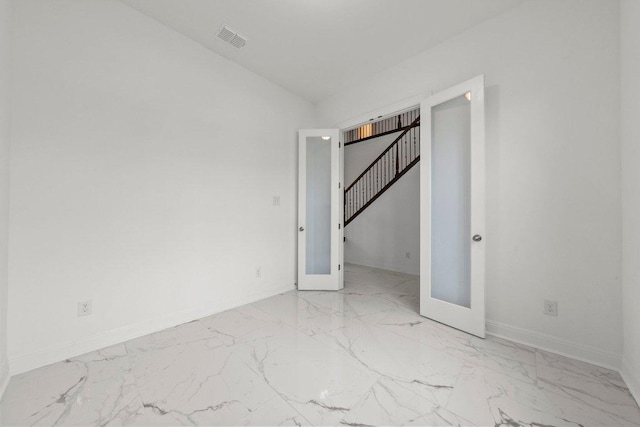empty room with french doors, marble finish floor, stairs, baseboards, and visible vents