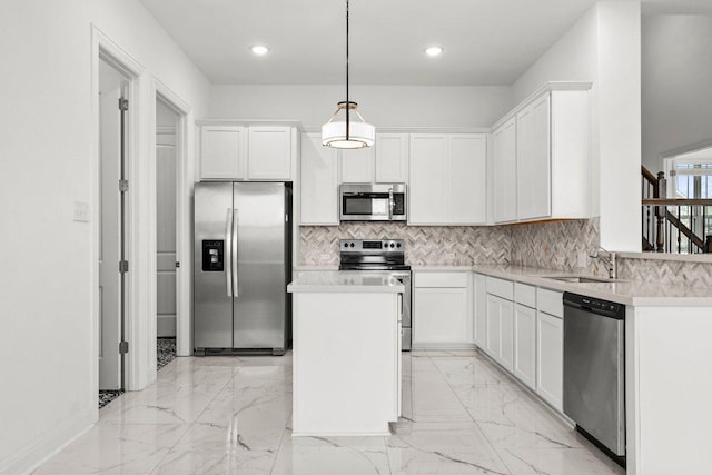 kitchen with decorative backsplash, a kitchen island, a sink, white cabinets, and stainless steel appliances