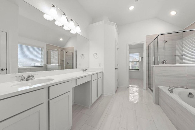 bathroom featuring a bath, a shower stall, a sink, and lofted ceiling
