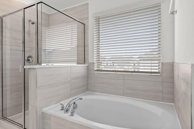 full bathroom featuring a stall shower and a bath