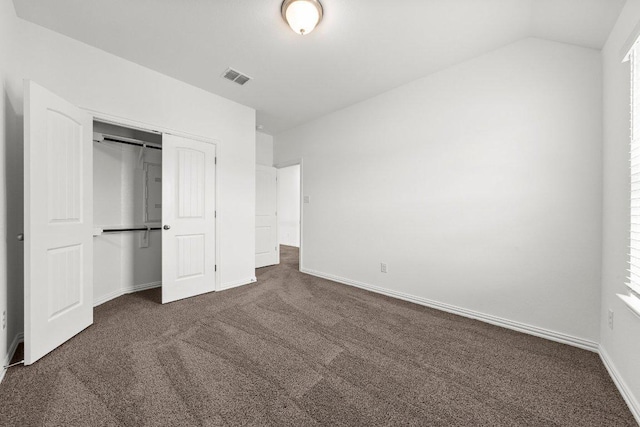 unfurnished bedroom with carpet, baseboards, vaulted ceiling, visible vents, and a closet
