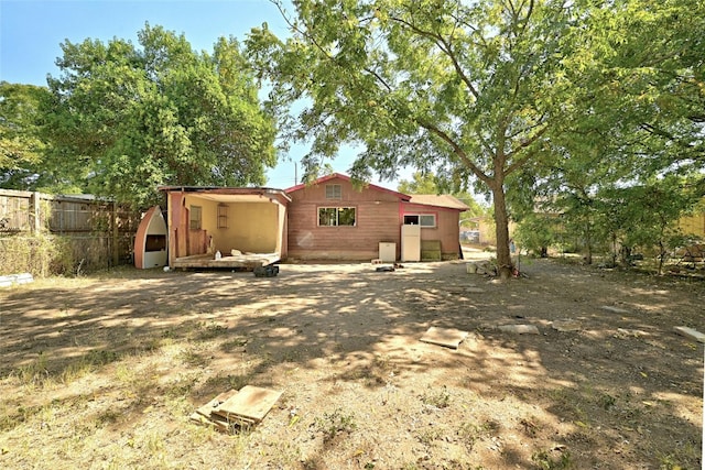 rear view of property featuring fence