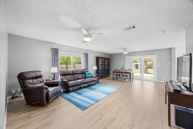 4325 Dos Cabezas Dr, Austin, TX 78749 - living area featuring ceiling fan, light wood-style floors, and a textured ceiling