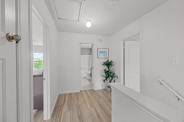 4325 Dos Cabezas Dr, Austin, TX 78749 - hallway featuring light wood-style floors, a textured ceiling, and baseboards