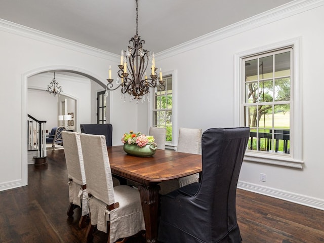 dining area with baseboards, arched walkways, wood finished floors, and a chandelier