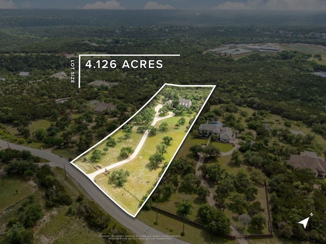 bird's eye view with a wooded view