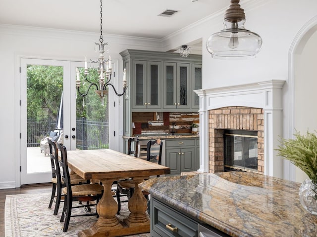 dining space with arched walkways, dark wood finished floors, ornamental molding, and a fireplace
