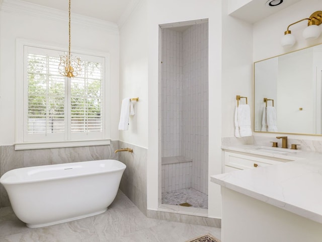 bathroom with an inviting chandelier, a tile shower, vanity, ornamental molding, and a soaking tub