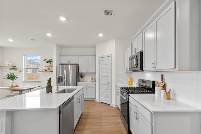kitchen with a sink, stainless steel appliances, recessed lighting, decorative backsplash, and visible vents