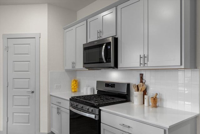 kitchen with light countertops, stainless steel appliances, and tasteful backsplash