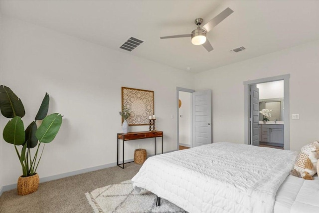 carpeted bedroom with visible vents, connected bathroom, baseboards, and ceiling fan