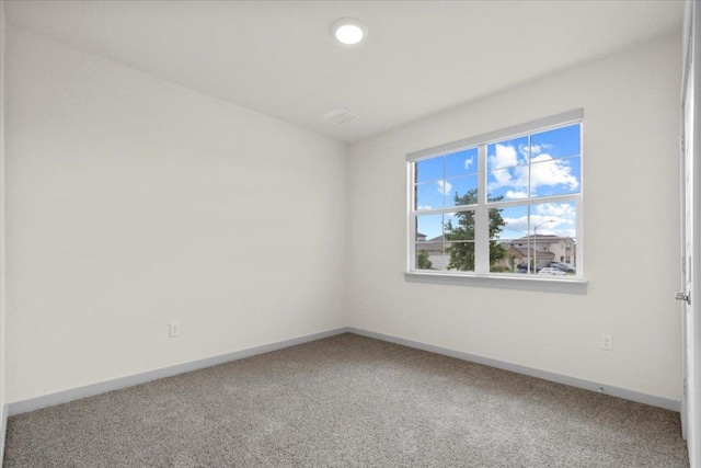 spare room featuring carpet flooring and baseboards