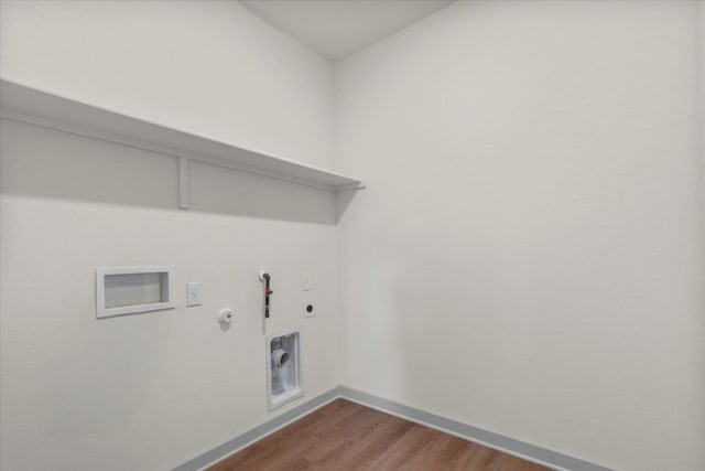 laundry area with hookup for an electric dryer, laundry area, hookup for a gas dryer, wood finished floors, and baseboards
