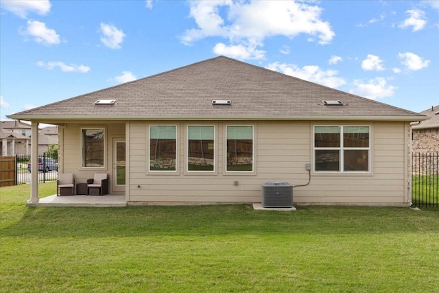 rear view of house featuring fence, a patio, a lawn, and central AC