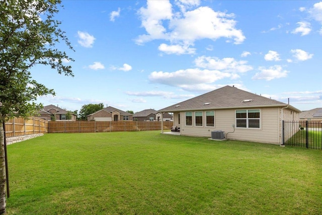 back of property featuring central air condition unit, a lawn, and a fenced backyard