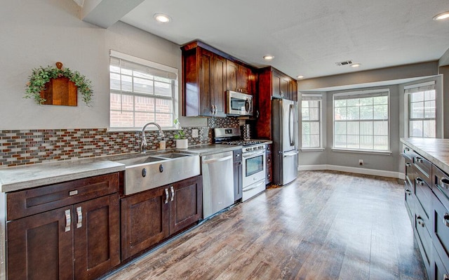 kitchen with visible vents, a sink, light wood finished floors, appliances with stainless steel finishes, and a wealth of natural light
