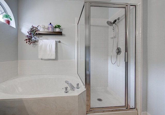 bathroom with a bath and a shower stall