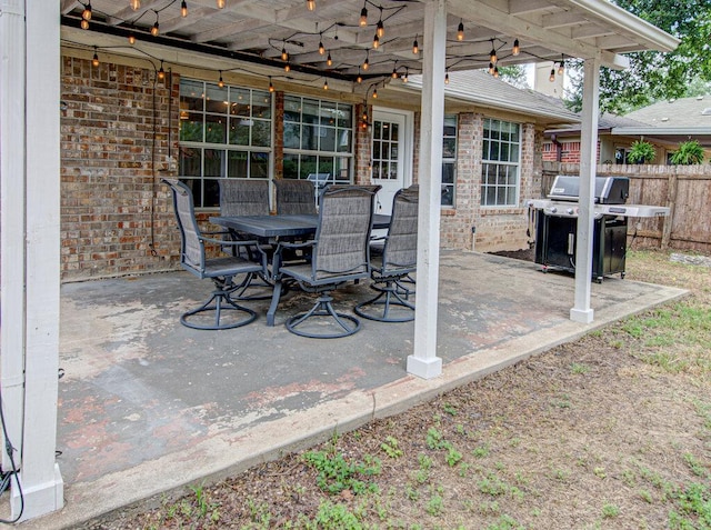 view of patio featuring outdoor dining space, fence, and area for grilling