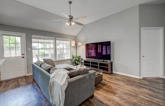 living area featuring baseboards, ceiling fan, vaulted ceiling, and wood finished floors