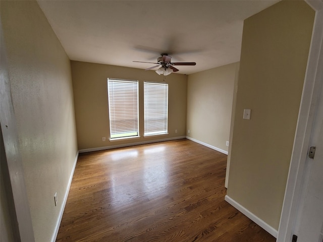 spare room with baseboards, ceiling fan, and wood finished floors