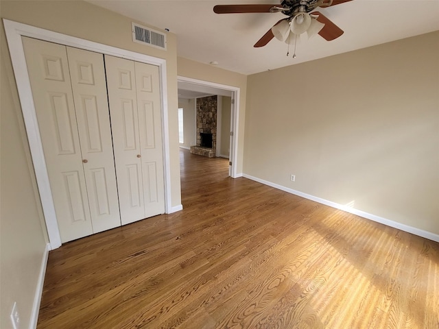 unfurnished bedroom featuring visible vents, baseboards, wood finished floors, and a closet