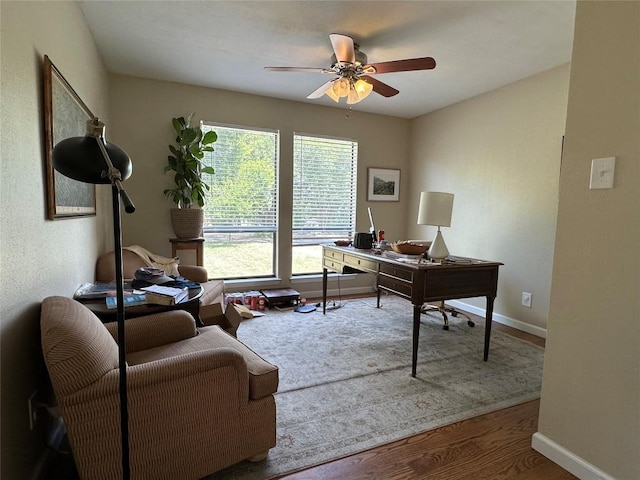 office space with baseboards, a ceiling fan, and wood finished floors