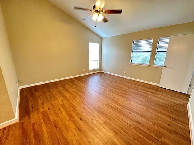 unfurnished room with baseboards, ceiling fan, wood finished floors, and vaulted ceiling
