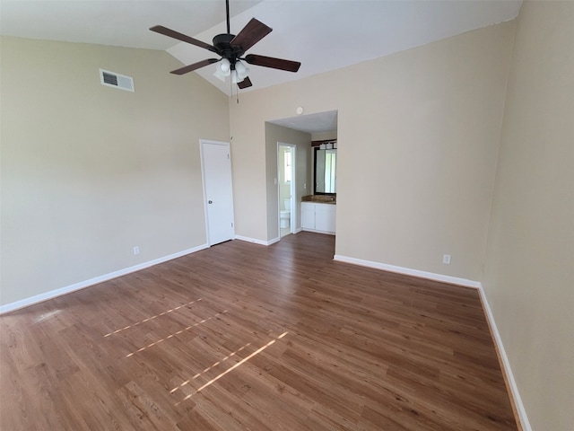 unfurnished room featuring visible vents, wood finished floors, baseboards, high vaulted ceiling, and a ceiling fan