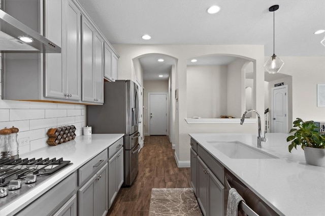 17111 Calipatria Ln, Pflugerville, TX 78660 - kitchen with a sink, wall chimney exhaust hood, gray cabinetry, arched walkways, and recessed lighting