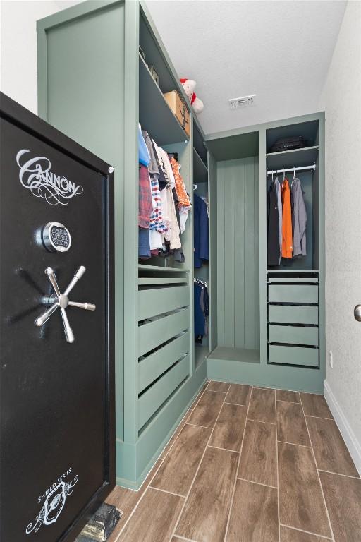walk in closet featuring wood finish floors and visible vents