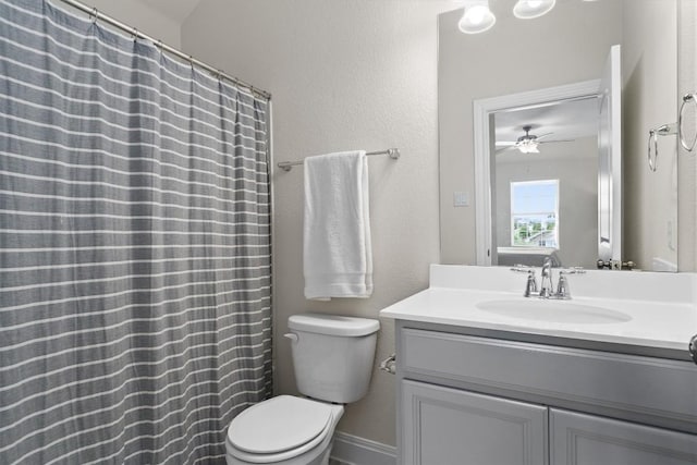 bathroom with ceiling fan, a textured wall, vanity, toilet, and curtained shower