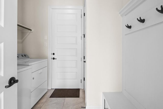 clothes washing area featuring washing machine and clothes dryer, laundry area, and light tile patterned floors