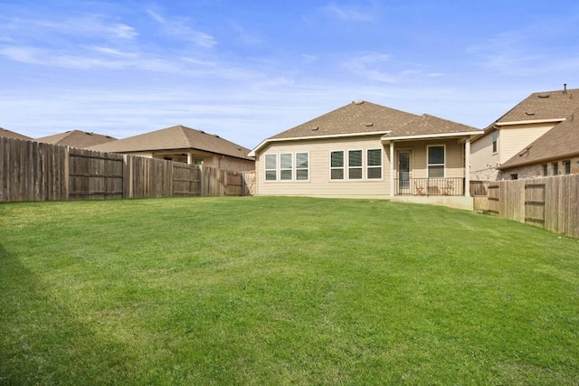 back of house featuring a lawn and a fenced backyard