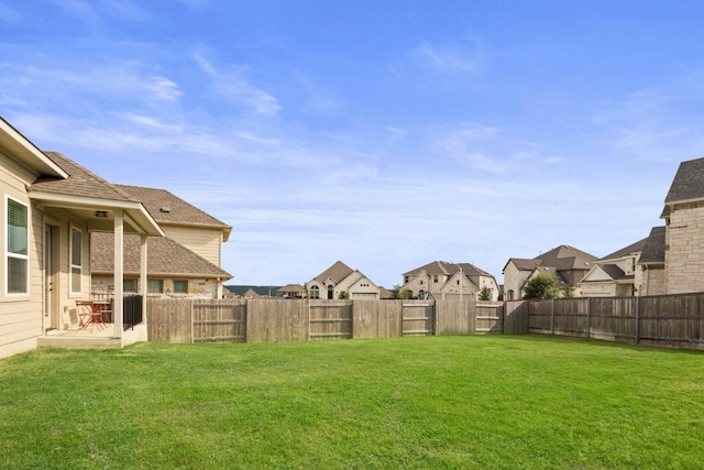 view of yard with a residential view, a fenced backyard, and a patio area