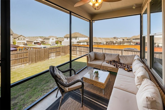 sunroom with a ceiling fan, outdoor lounge area, and a residential view