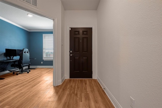 office with baseboards, ornamental molding, visible vents, and light wood-type flooring