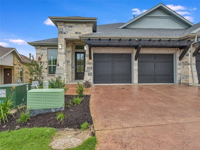 view of front facade with concrete driveway, an attached garage, a shingled roof, and stone siding