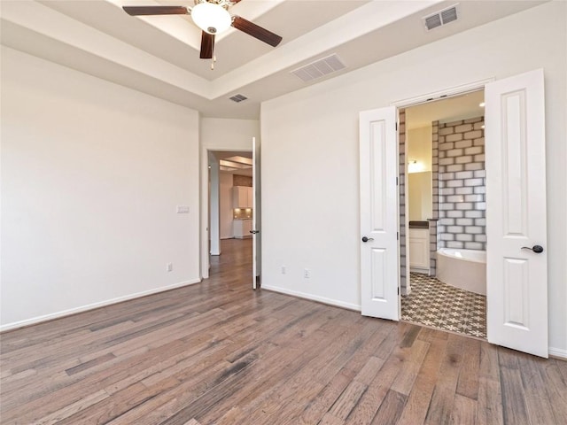 unfurnished bedroom featuring baseboards, dark wood-style flooring, and visible vents