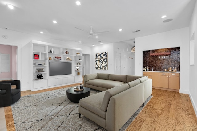 111 Crest View Dr, Lakeway, TX 78734 - living room featuring light wood-style flooring, bar with sink, recessed lighting, a ceiling fan, and built in features