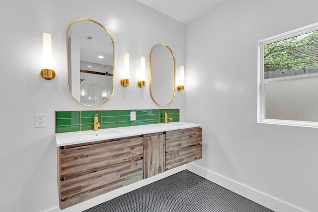 full bathroom with a sink, baseboards, tasteful backsplash, and double vanity