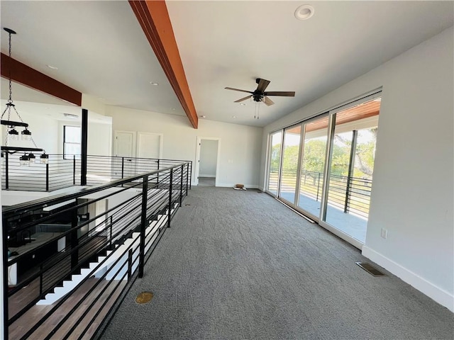 spare room featuring ceiling fan, visible vents, baseboards, carpet floors, and beamed ceiling