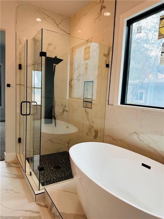 full bath with a freestanding tub, a marble finish shower, a healthy amount of sunlight, and marble finish floor