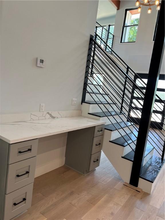 6308 Hudson Bend Rd, Austin, TX 78734 - staircase with wood finished floors, built in desk, and a chandelier